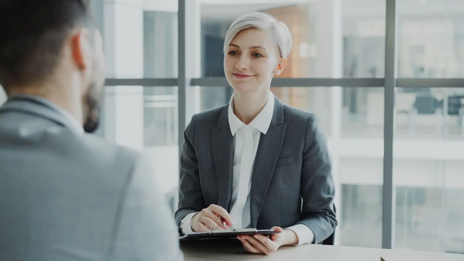 A recruitment consultant interviewing a candidate in a bright modern office