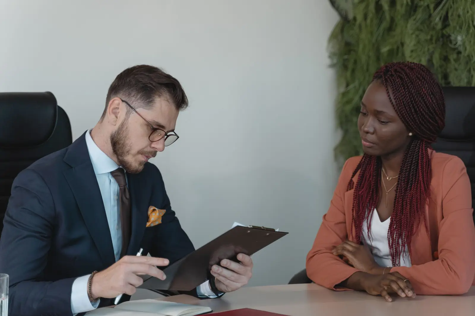 A recruiter reviews notes with a candidate across a meeting table